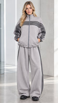 Front full view of woman wearing Heather Grey striped zip-up track jacket and wide-leg sweatpants set