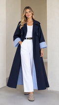 Front view of model wearing Navy Blue maxi trench duster coat with striped cuffs and white pants