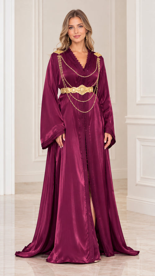 Front full view of woman wearing burgundy satin embellished caftan maxi dress with gold chain belt