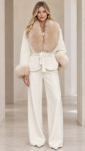 Front full view of woman wearing cream belted jacket with faux fur trim and wide leg pants