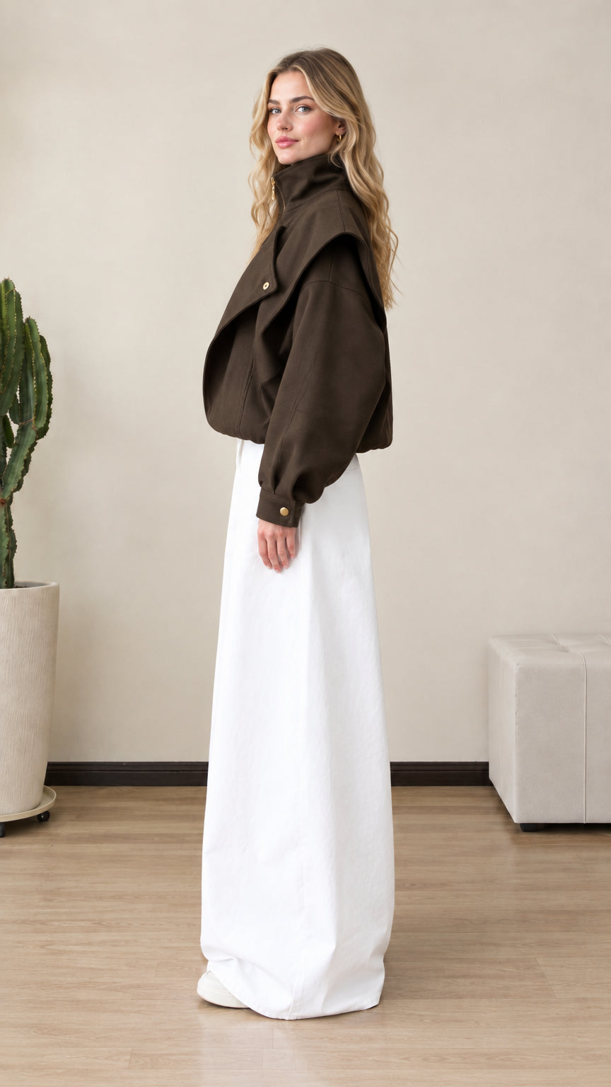 Side profile view of woman wearing dark brown structured zip jacket