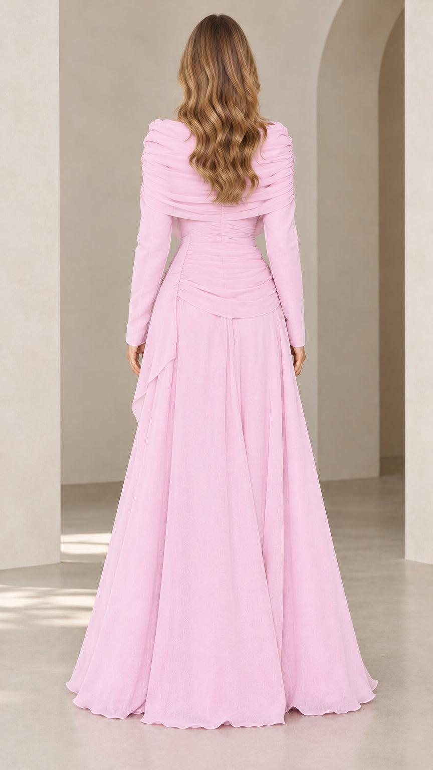Back view of model wearing flowing pink floor length long sleeve gown