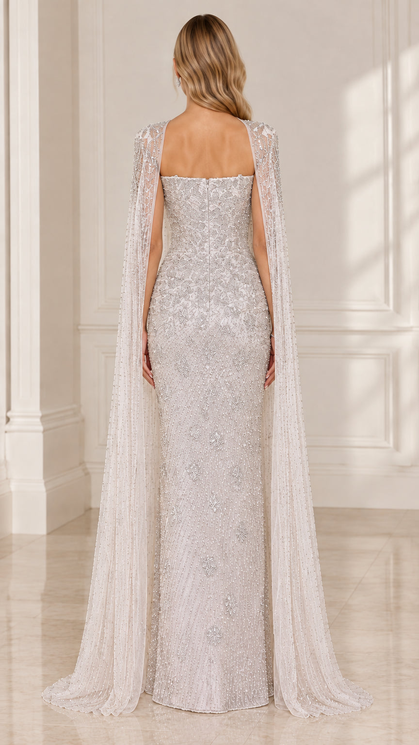 Back view of silver beaded maxi gown showing straight backline and trailing sheer cape