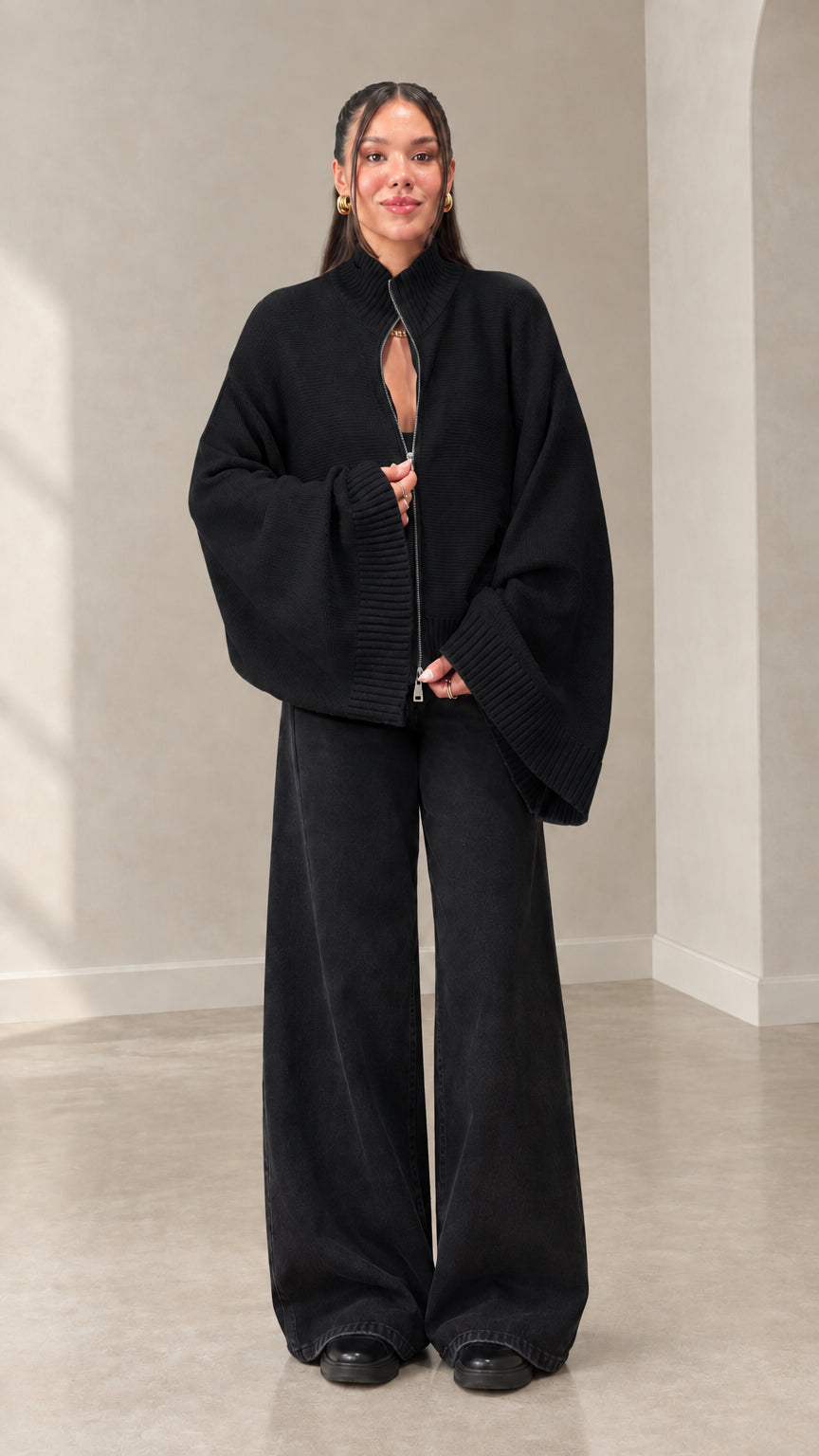 Woman wearing black zip-front batwing sleeve knit cardigan