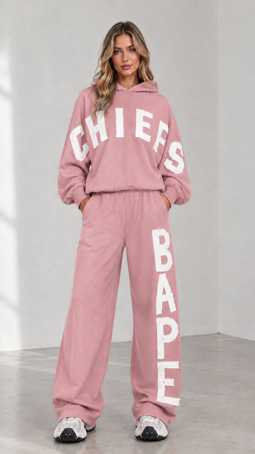 Full-body view of woman wearing pink letter print oversized hoodie and sweatpants set