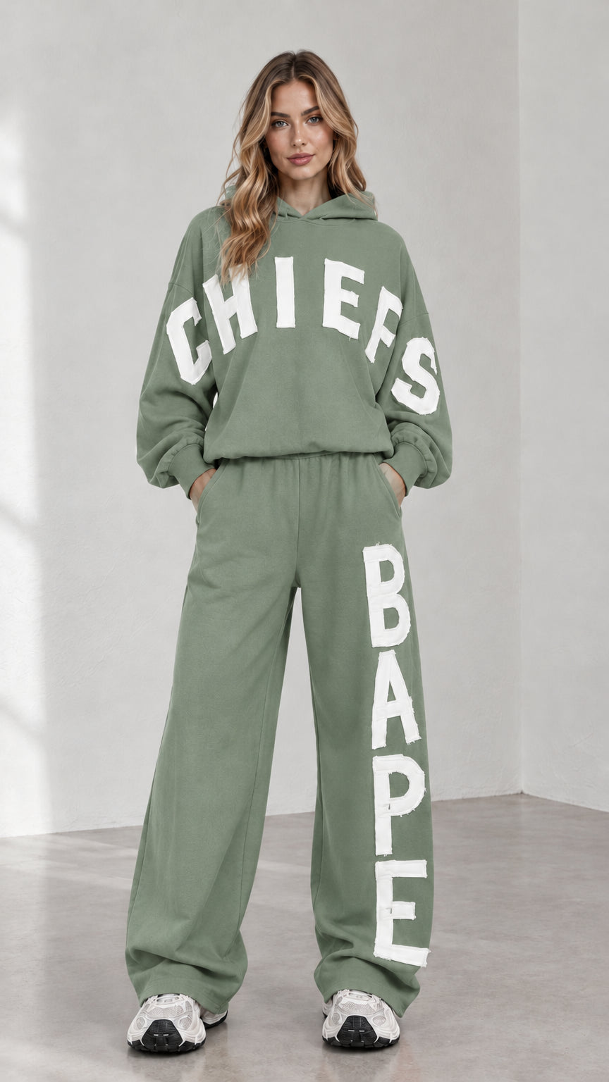 Full-body view of woman wearing sage green letter print oversized hoodie and sweatpants set