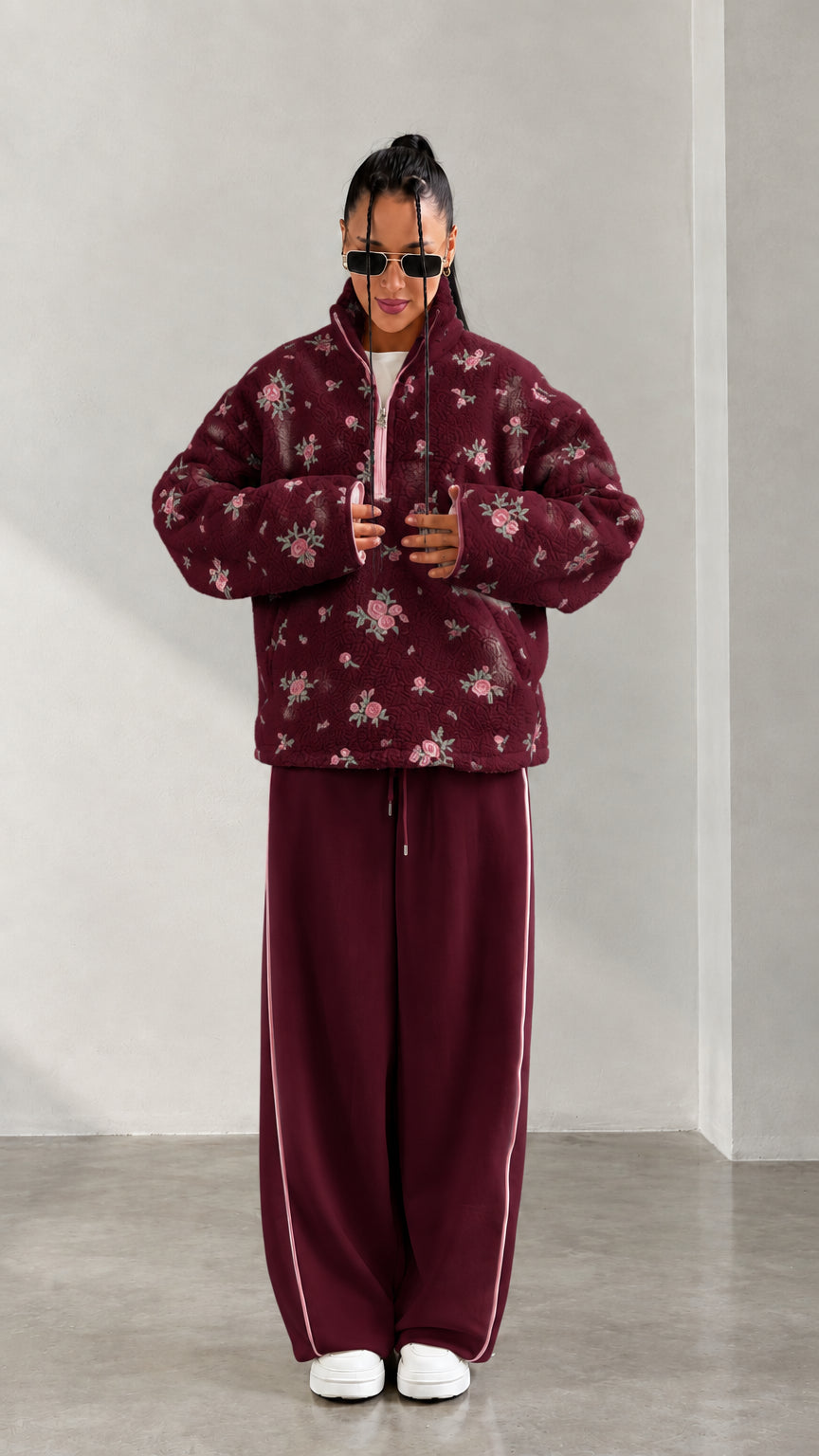 Front view of model wearing burgundy floral print half-zip fleece pullover
