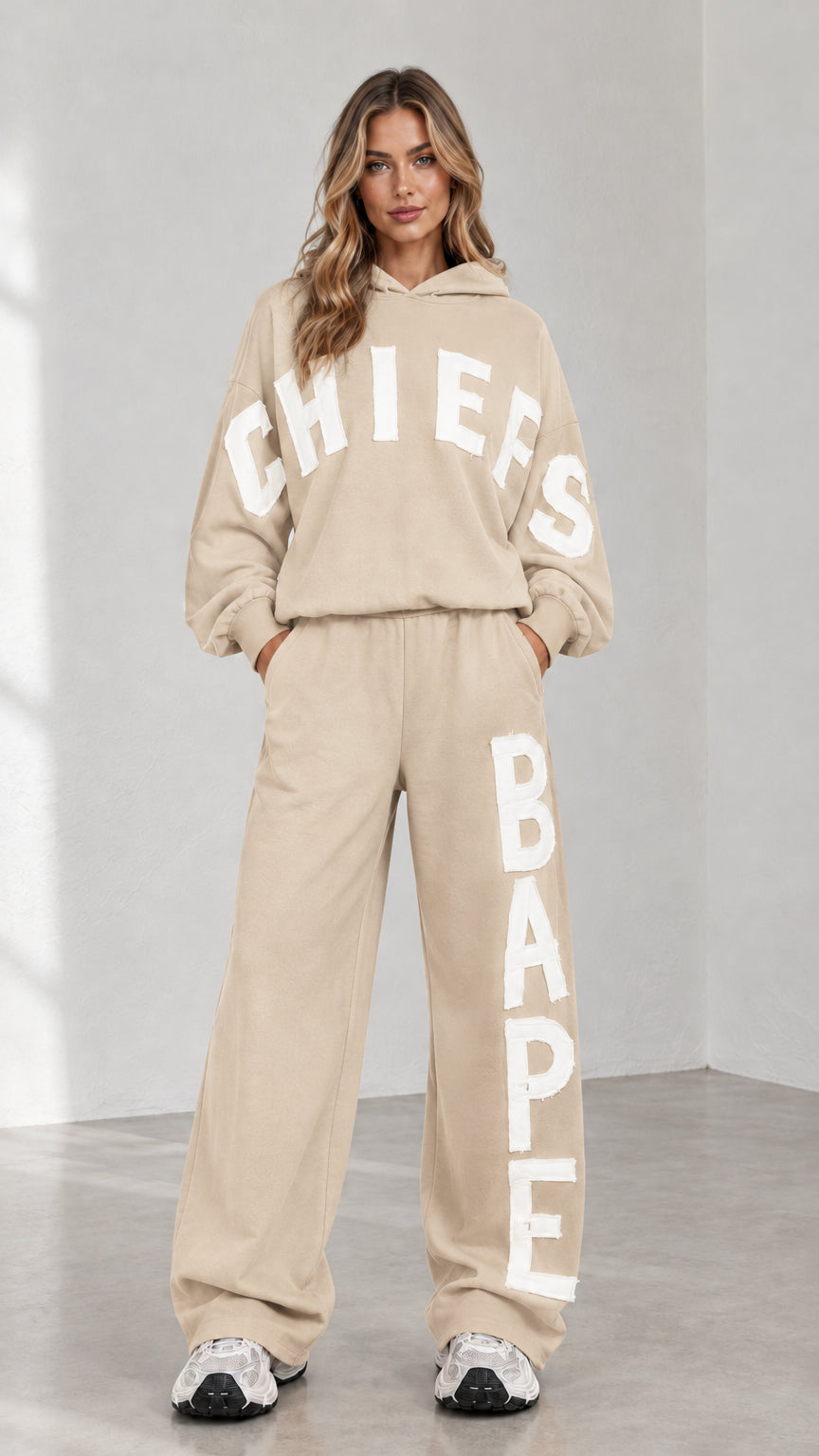 Full-body view of woman wearing beige letter print oversized hoodie and sweatpants set